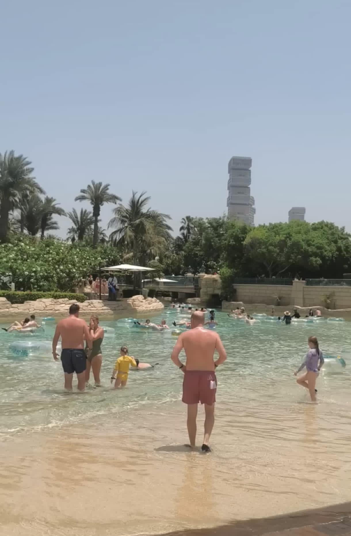 Families and children floating on tubes in the Lazy River at Aquaventure Waterpark Dubai, enjoying a relaxing ride under the sun.