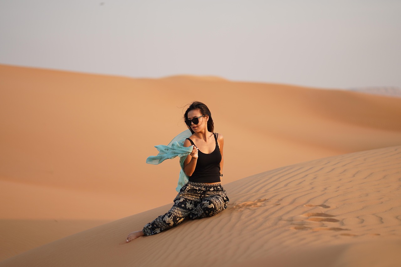 Dubai like a local: golden desert dunes at sunset with distant city skyline, highlighting authentic Emirati experiences
