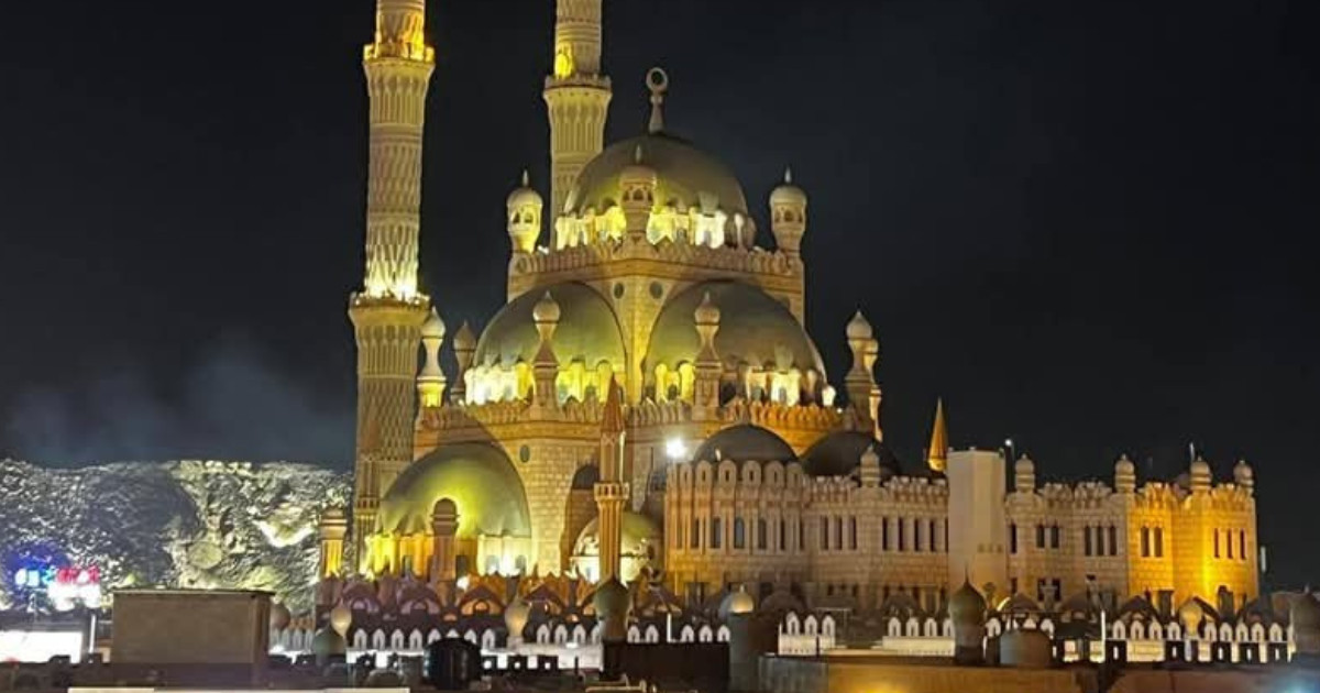 The illuminated gold and sand-colored domes and minarets of Al Sahaba Mosque at night in Sharm El Sheikh’s Old Market.