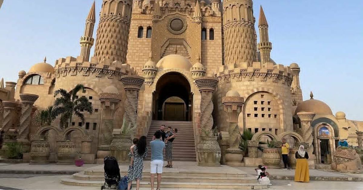 Tourists standing in front of the ornate entrance of Al Sahaba Mosque in Old Market Sharm El Sheikh during golden hour.