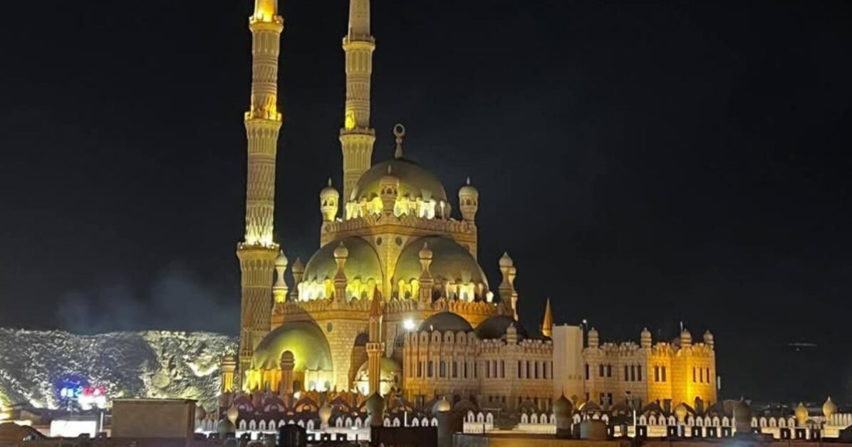 Illuminated Al Sahaba Mosque at night in Old Market Sharm El Sheikh, showing golden domes and towering minarets.